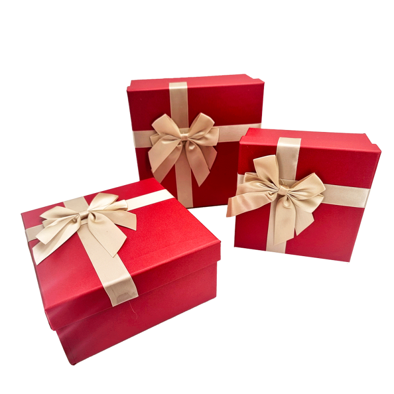 Pequeña caja de regalo elegante de color rojo iridiscente con lazo de raso dorado