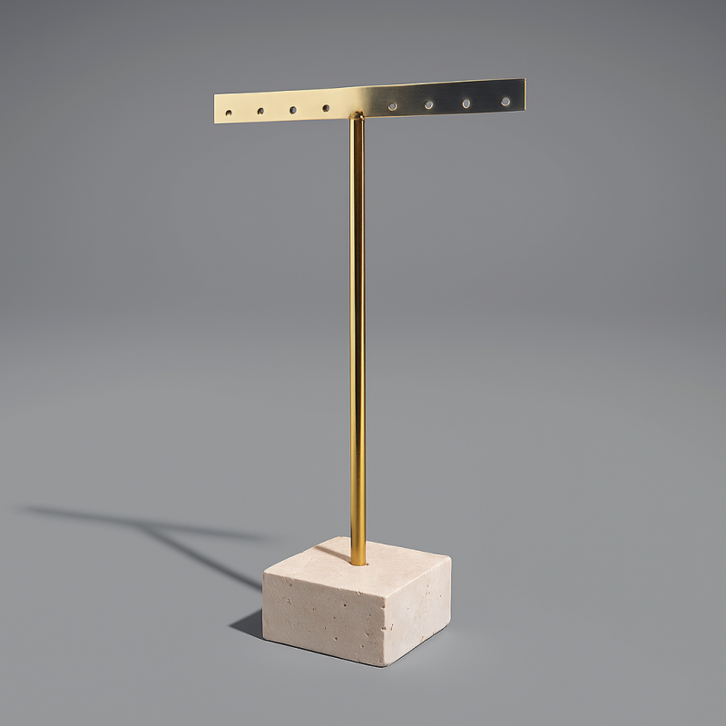 Pequeño joyero de metal dorado sobre base de piedra en forma de T