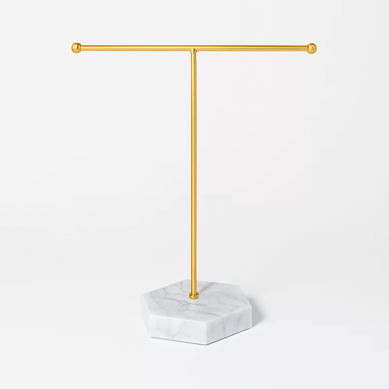 Joyero de metal dorado con forma de T sobre base con efecto mármol gris