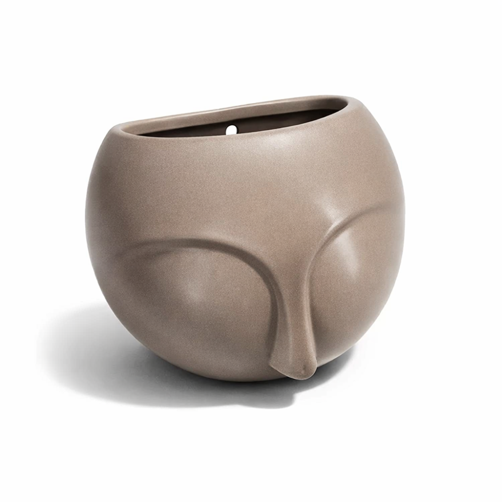 Piccolo vaso da parete in ceramica beige con motivo a volto scolpito.